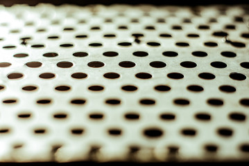 Wall Mural - Perforated aluminium sheet of metal texture. Surface with depth of field, abstract industrial mesh old grunge background