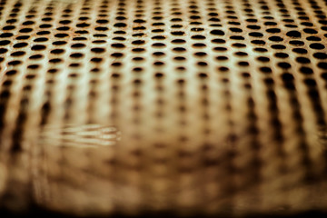 Wall Mural - Perforated rusty iron sheet texture. Surface of industrial mesh with depth of field. Horizontal blure background