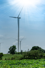 Wind generators turbines electricity and agricultural fields on a summer day with blue sky. Windmills energy production with clean and renewable energy .Energy wind farm conservation concept