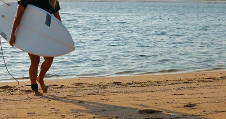 Wall Mural - Young surfer woman beginner take off leash from leg