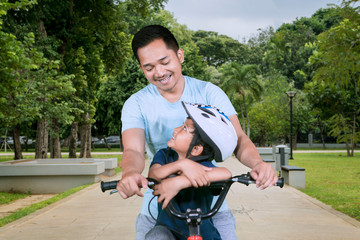 Sticker - Happy father riding bicycle with his son in the park