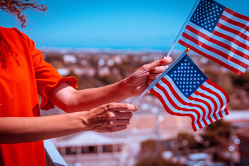 Woman hands with USA national flag celebrating american national holiday like 4ht of July, Flag day, national day or memorial day.