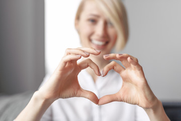 Wall Mural - Blurred lady gesturing heart with hands