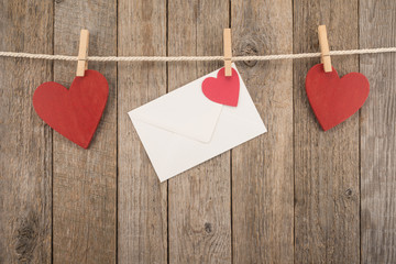 Wall Mural - White envelope and red hearts on a rope with pegs