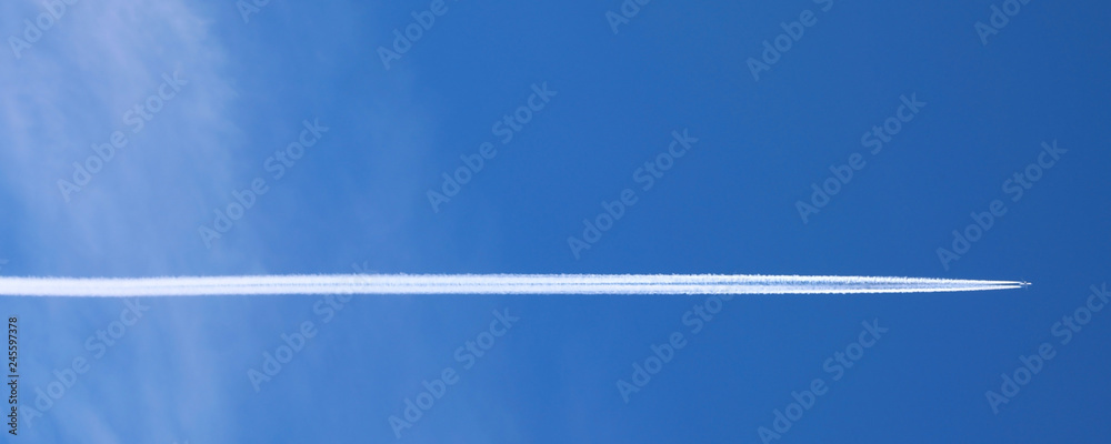 Engine exhaust white contrails forming behind an aircraft - obrazy, fototapety, plakaty 