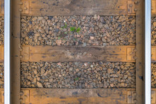 Old Rusty Railroad With Wooden Sleepers On The Rocks Closeup