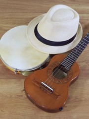 A samba player (sambista) hat and two Brazilian musical instruments: cavaquinho and pandeiro (tambourine). The instruments are widely used to accompany samba and choro, two popular Brazilian rhythms.