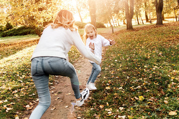 Happy daughter with mother is having fun walking in the park.