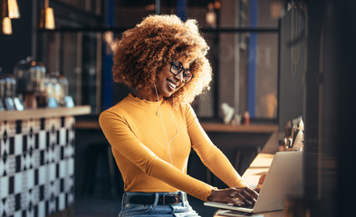 Smiling woman on a video call sitting at a coffee shop