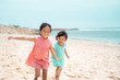© Odua Images - two little girl walking together on white sand beach