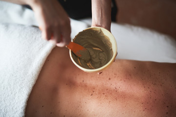 Wall Mural - Close up of healthy spa mud in therapist hands