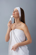 © Yakobchuk Olena - Attractive young lady in white headband using pore cleansing brush after bath