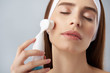 © Yakobchuk Olena - Beautiful young woman with perfect skin using pore cleansing brush