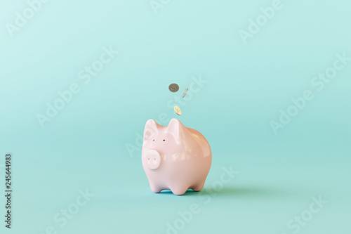 Fotografía Pink piggy bank with coins on pastel blue background