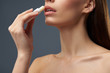 © Yakobchuk Olena - Young lady with beautiful full lips using hygienic lipstick