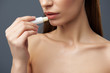 © Yakobchuk Olena - Charming young woman with beautiful full lips using hygienic lipstick
