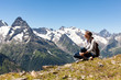 © Mary - tourist girl sitting on a background of mountains