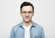 © Raisa Kanareva - Portrait of a smart young man wearing eyeglasses standing against white background