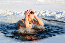 A Young Man Is Preparing To Dive Into The Ice Hole. Winter, Cold, Open Water.