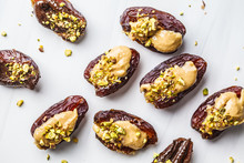 Dates Stuffed With Peanut Butter And Pistachios On White Background.