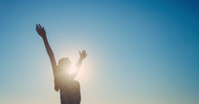 Silhouette Of A Girl With Her Hands Wide Apart, Blue Sky Background