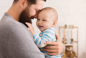 Loving father embracing his cute baby son