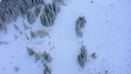 Wall Mural - Aerial view of the ski slope in the mountains where skiers ride.