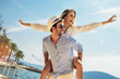 © Mediteraneo - Couple in love, enjoying the summer time by the sea.Joyful girl piggybacking on young boyfriend having fun.