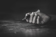 © Tinnakorn - Woman hand of a drug addict and a syringe with narcotic syringe lying on the floor, Overdose, drug concept.