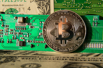 Wall Mural - silver bitcoin coin with dollars and computer motherboard, cryptocurrency mining and investing conce