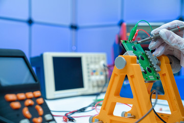 Canvas Print - Fixing electronics PCB board in service /  workbench with electronics measuring instruments