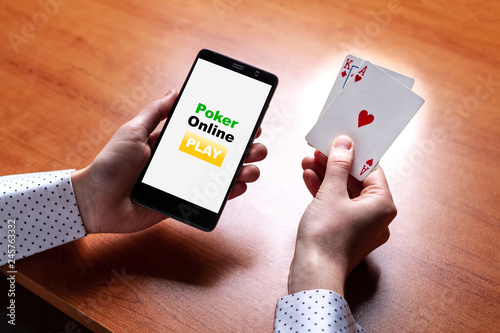 Fotografía Close up of poker player with playing cards and smartphone in hands at the table