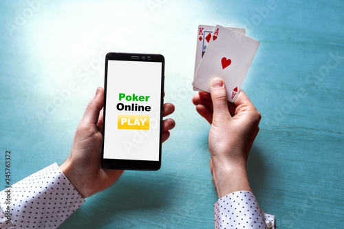Cuadros en Lienzo Close up of poker player with playing cards and smartphone in hands at the table