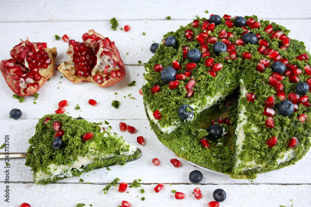 Ciasto "zielony mech" ze szpinakiem ozdobione pestkami granatu i jagodami - obrazy, fototapety, plakaty 