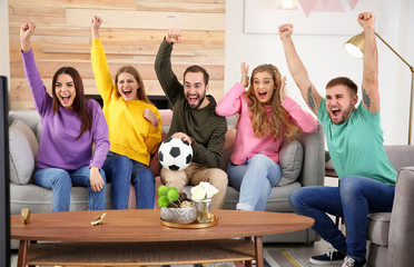 Wall Mural - Group of friends celebrating victory of favorite soccer team in living room