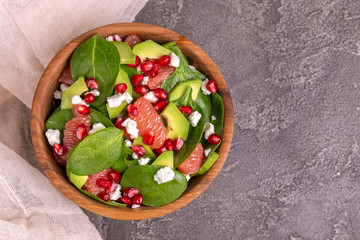 Wall Mural - Tasty salad with grapefruit, spinach, feta, avocado and pomegranate