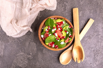 Wall Mural - Tasty salad with grapefruit, spinach, feta, avocado and pomegranate