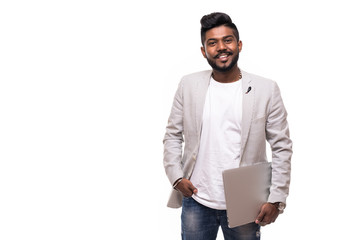 young handsome indian hipster man holding laptop isolated on white background