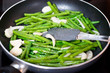 Green beans with onion and garlic ready for cooking in frying pan. Close up view of green beans on a frying pan