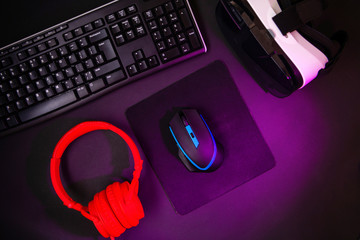 Sticker - Top view a gaming gear, mouse, keyboard, joystick, headset, VR Headset on black table background.