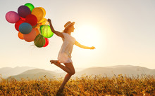 Happy Woman With Balloons At Sunset In Summer