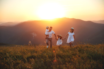 Happy family: mother, father, children son and daughter on sunset