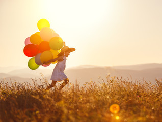 Poster - . happy child with balloons at sunset in summer