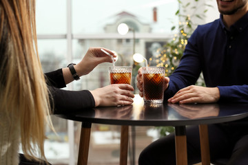 Couple with glasses of cold cola at table in cafe, closeup