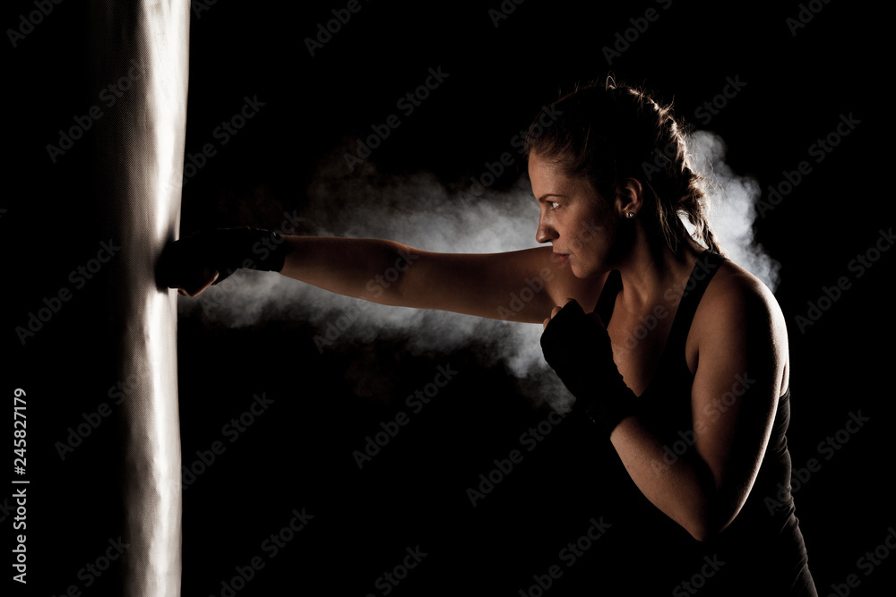 фотографія kick fighter girl punching a boxing bag