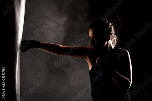 фотографія kick fighter girl punching a boxing bag