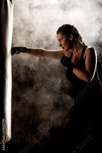 kick fighter girl punching a boxing bag Фотошпалери