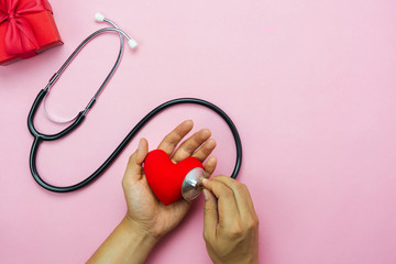 Wall Mural - Table top view aerial image of accessories healthcare & medical with Valentines day background concept.Flat lay items for doctor using telescope checking heart rate colorful love shape on pink paper.