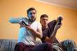 © phoenix021 - Intense video gaming, two friends, young adult and teenager playing