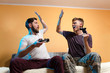 © phoenix021 - Young adult man and teenager giving high five to each other while playing video games